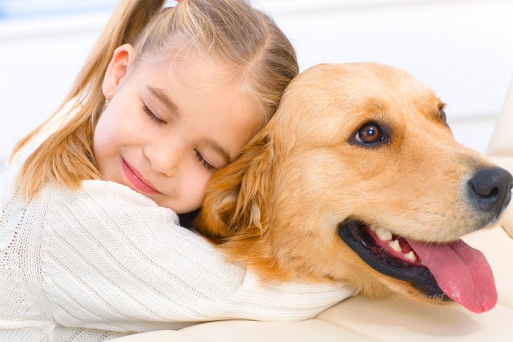 Una bambina abbraccia un cane