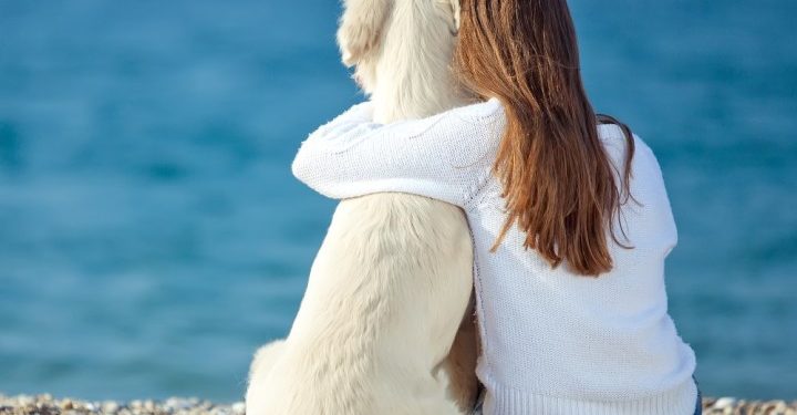 Una ragazza abbraccia il suo cane