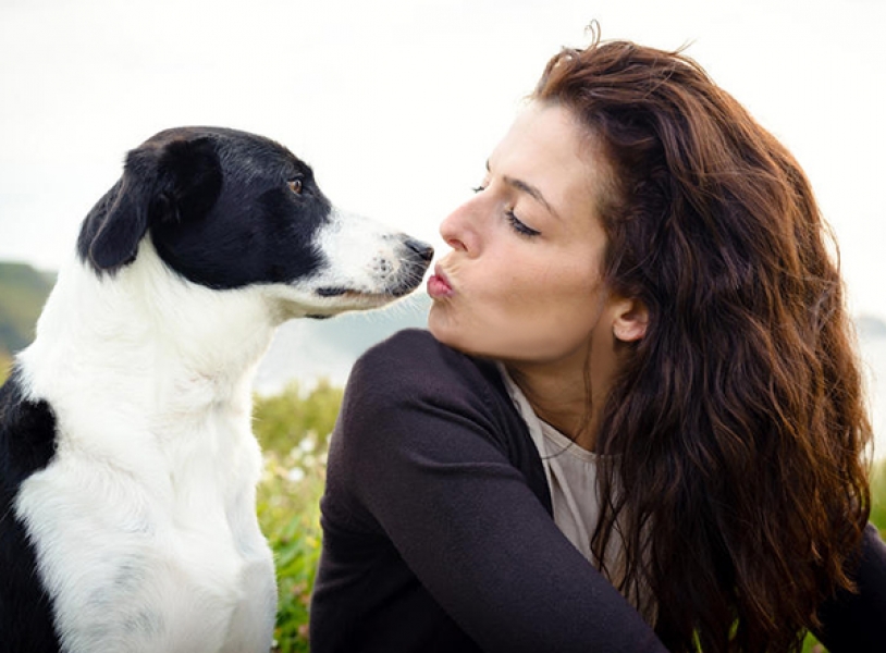 Una ragazza che bacia il proprio cane