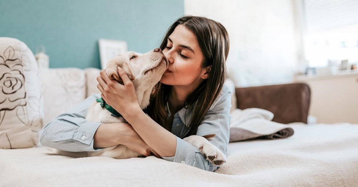 cucciolo di cane e ragazza su letto