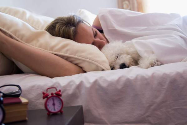 una donna dorme abbracciata al cane