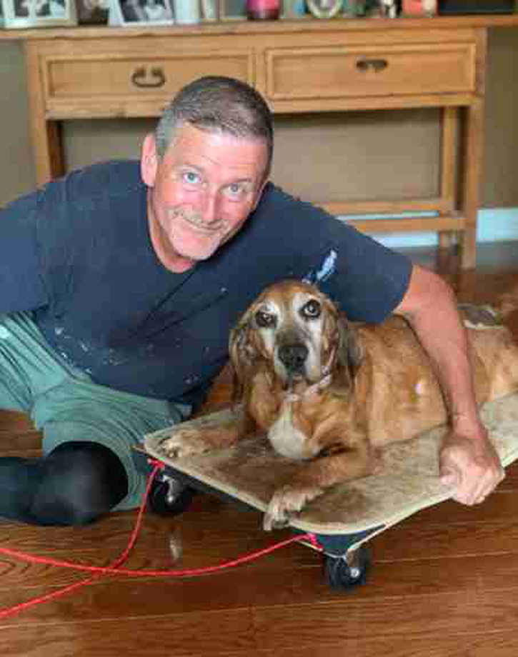 Cane in un carrellino vicino al suo proprietario