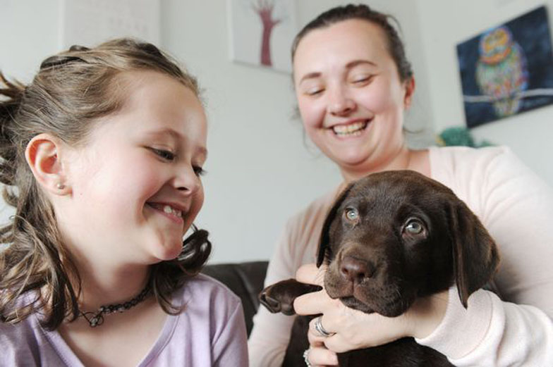 Cane insieme ad una bambina e ad una donna