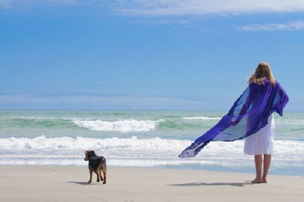 donna con cane in spiaggia