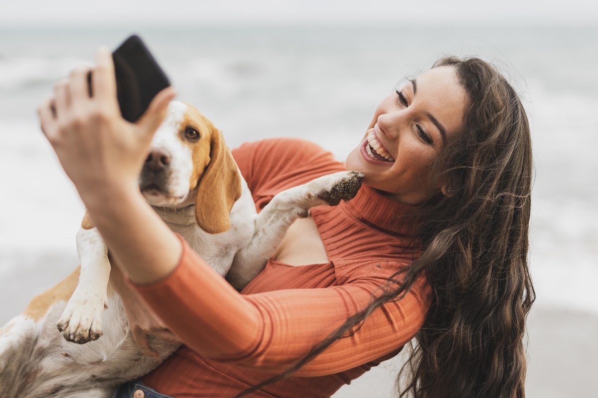 ragazza in spiaggia con il suo beagle