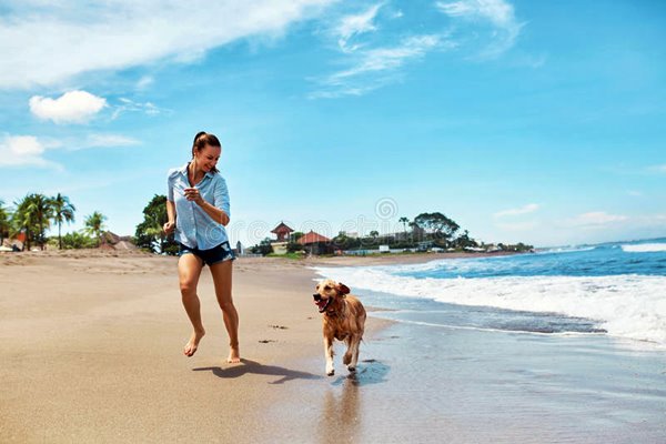 ragazza corre in spiaggia con il cane