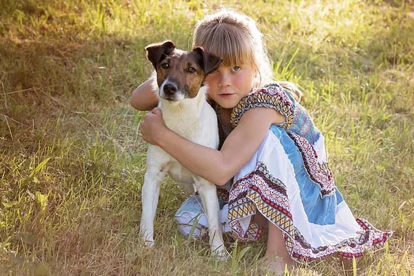 Cagnolino abbracciato da una bambina