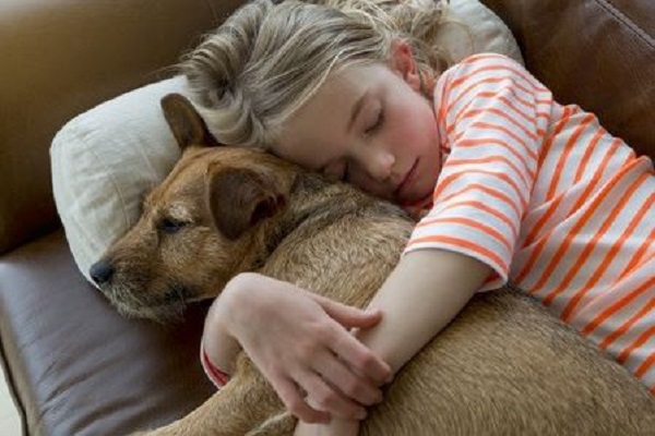 bambina dorme abbracciando un cucciolo