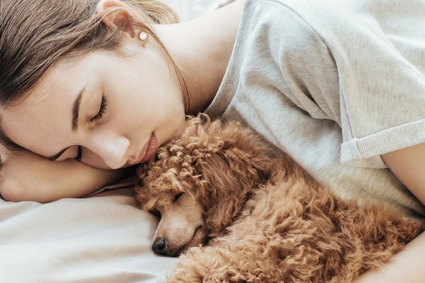 ragazza e cane dormono abbracciati