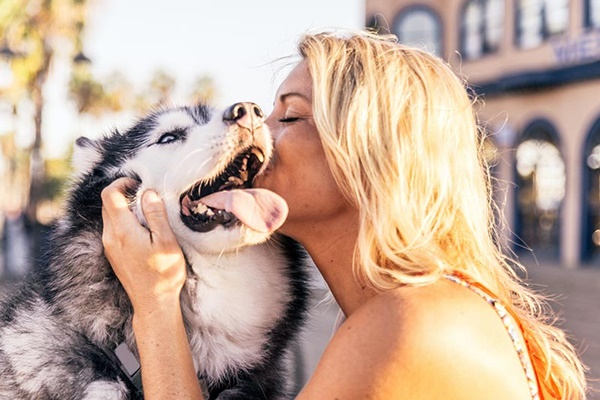 ragazza bionda bacia il suo cane