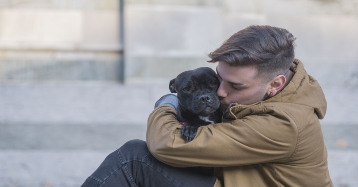 cane nero che abbraccia ragazzo