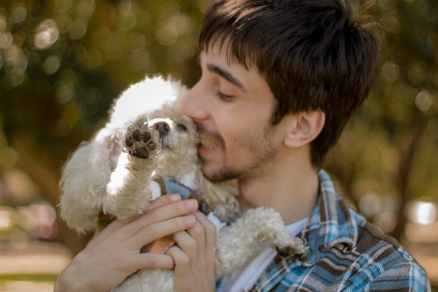 ragazzo con la barba abbraccia il suo cane