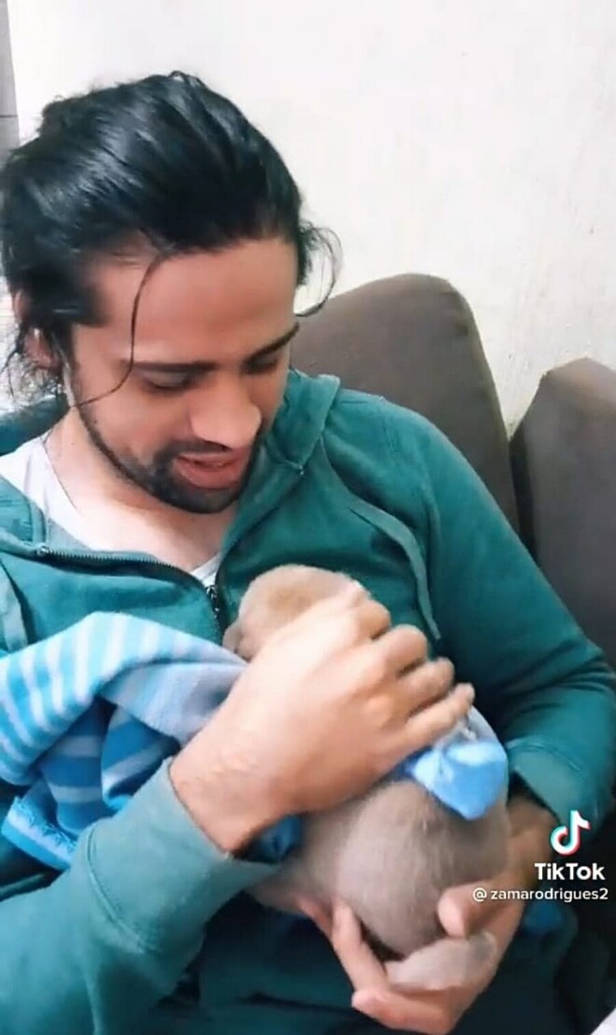uomo piange con cucciolo in braccio
