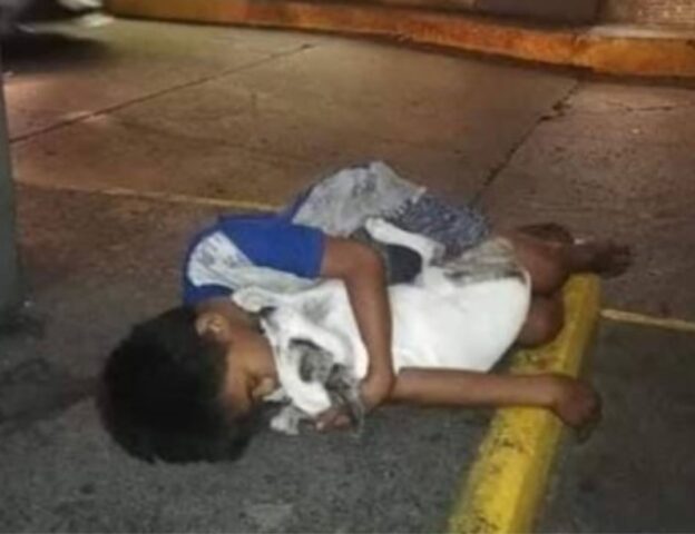 Bambino senzatetto si aggrappa al suo cagnolino per darsi amore e calore mentre tutti passano