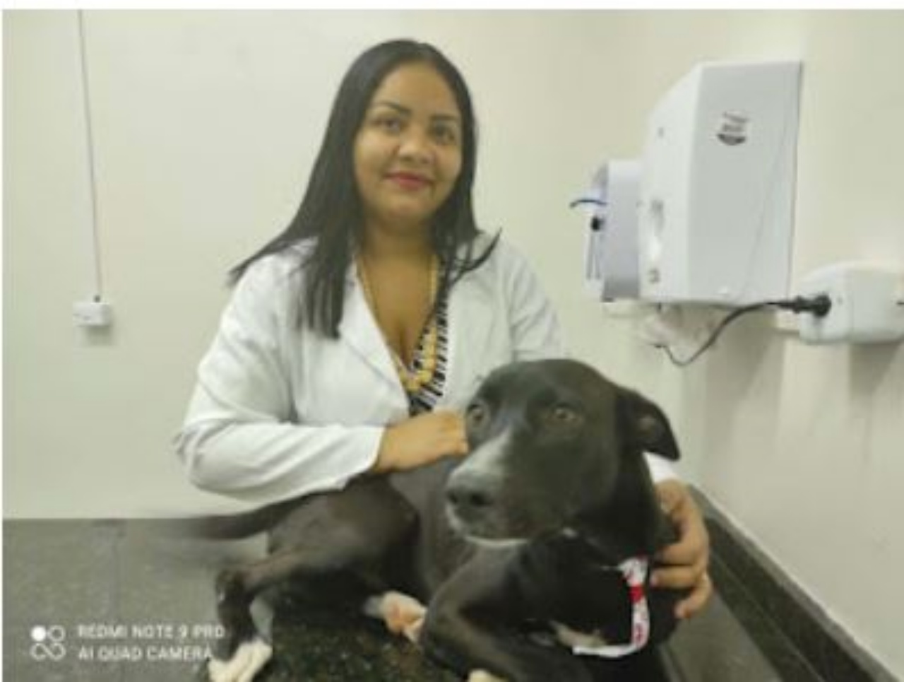 un cane dal mantello nero con una dottoressa in clinica 