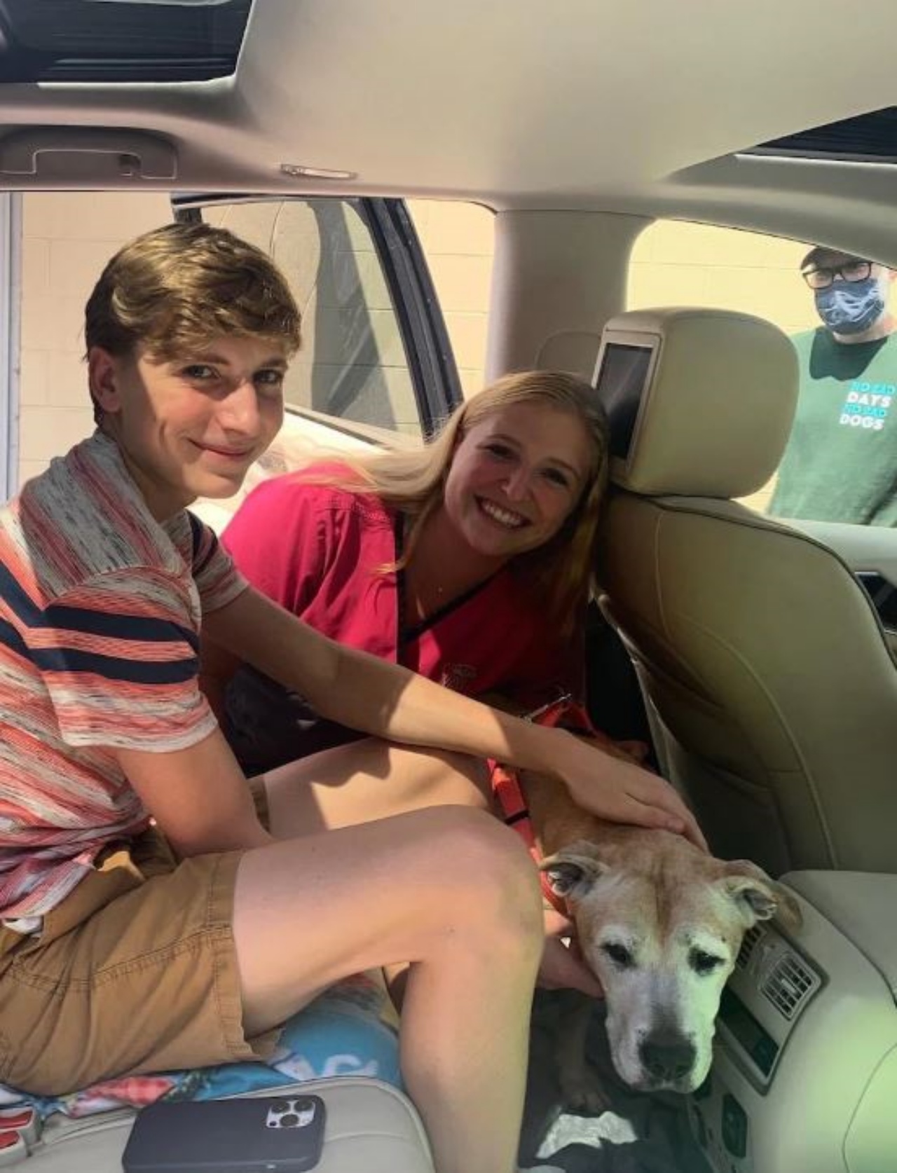 un cane in una macchina con due persone
