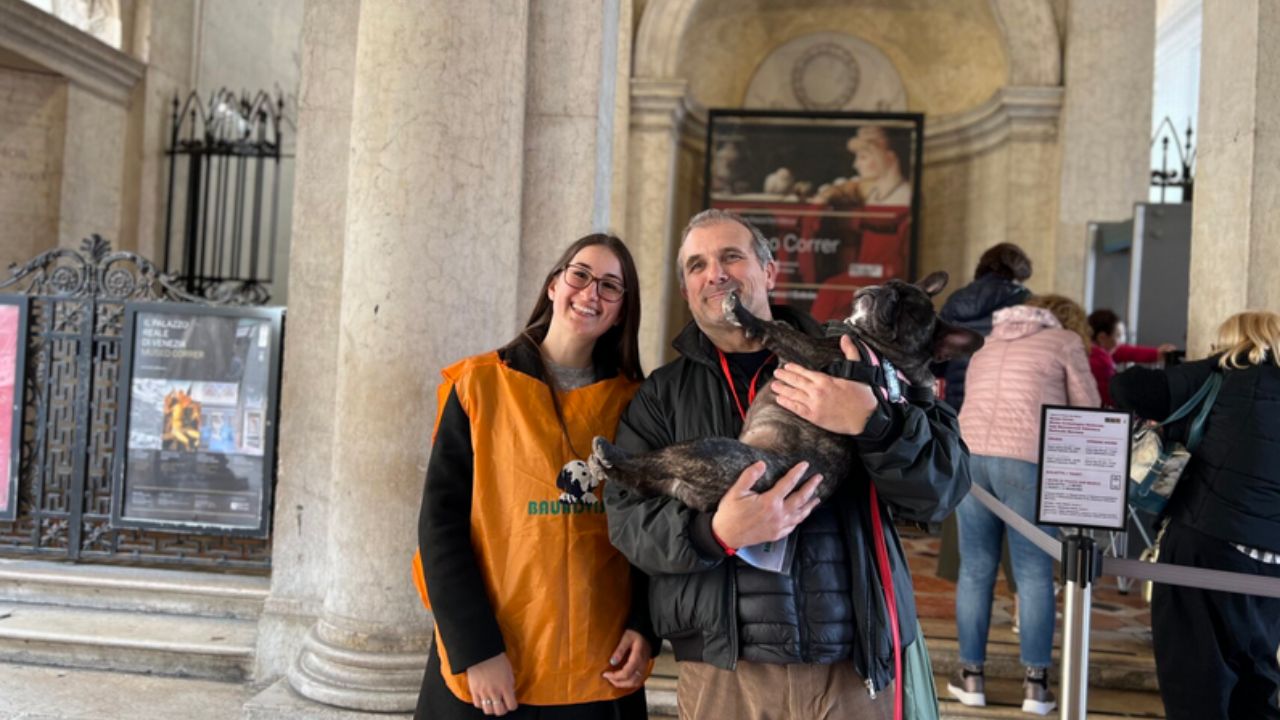 uomo sorridente che tiene in braccio un cane